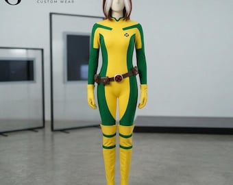 May include: A full-body costume featuring a yellow and green jumpsuit with long sleeves, yellow gloves, and yellow knee-high boots. A brown utility belt with a circular red and black emblem is worn at the waist. The mannequin has brown hair with white streaks.