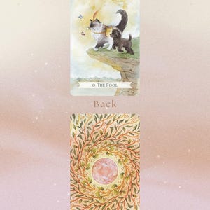 May include: Tarot card featuring a cat and dog on a cliff with a sun in the background. The card is titled "The Fool". The back of the card features a swirling pattern of leaves and a pink circle in the center.