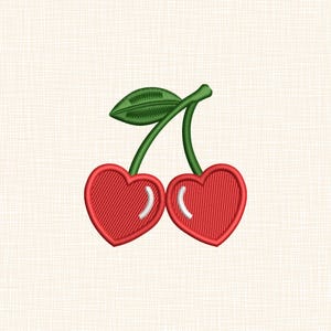 Puede incluir: Diseño bordado de dos cerezas rojas en forma de corazón con reflejos blancos, conectadas por un tallo y una hoja verdes. El diseño está cosido sobre una tela color crema, adecuado para varios proyectos de manualidades.