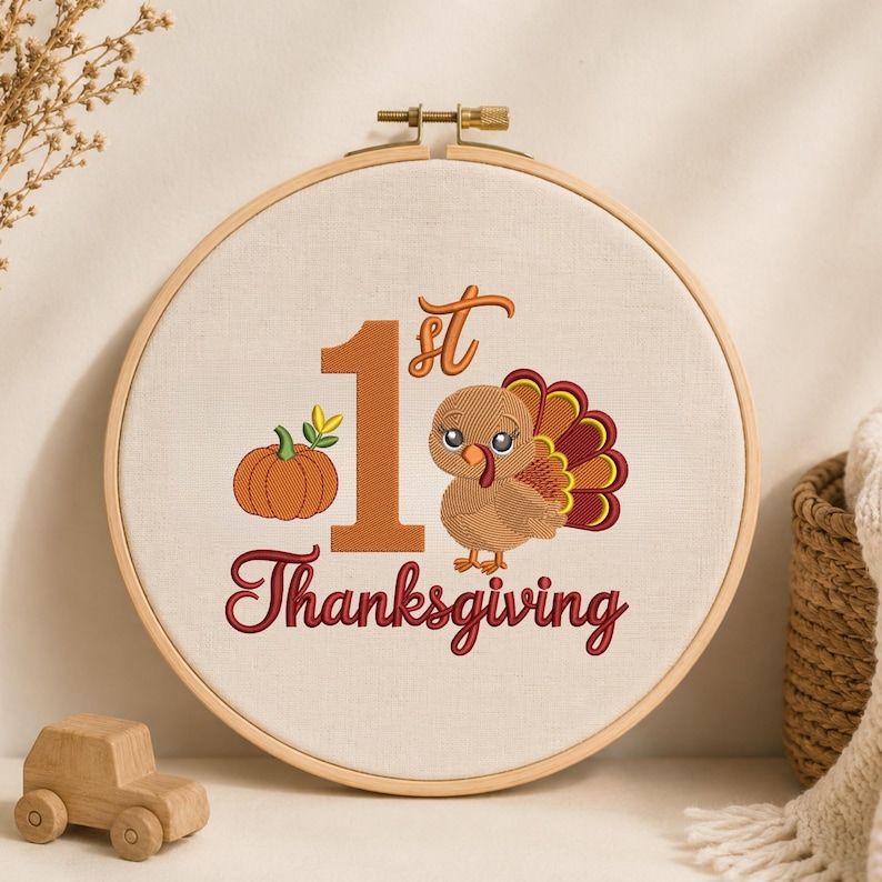 May include: A round wooden embroidery hoop containing white fabric with an embroidered design. The design features a large orange number 1, a small orange pumpkin, and a brown turkey with colorful feathers. The text reads 1st Thanksgiving.