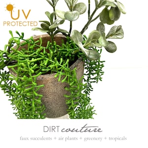 May include: A faux succulent plant arrangement in a brown textured pot. The plants are green and have a variety of shapes and sizes. The pot is labeled "DIRT couture faux succulents + air plants + greenery + tropicals".