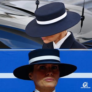May include: A navy blue hat with a wide brim and a white band. The hat is worn by a person wearing a dark suit and a white collared shirt. The image is a close-up shot of the hat and the person wearing it.