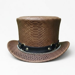 May include: A brown top hat with a snakeskin pattern. The hat features a black leather band with silver-colored metal rings and a chain. The hat has a wide brim and a tall, cylindrical crown, suitable for cosplay or costume events.