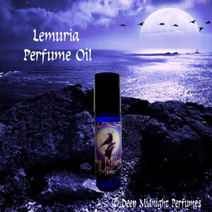 May include: A blue glass roller bottle with a black cap and a label that says "Lemuria Perfume Oil" and features a raven on a moonlit background. The label also says "Deep Midnight Perfumes".