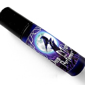 Op de afbeelding: Een donkerblauwe glazen fles met een zwarte dop en een etiket met de tekst "Deep Midnight Perfumes" met een raaf en een maanmotief.