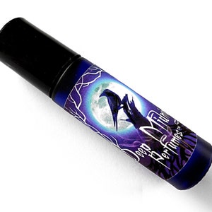 May include: A black roll-on bottle with a purple and blue label featuring a raven perched on a branch in front of a full moon. The label reads "Deep Midnight Perfumes".
