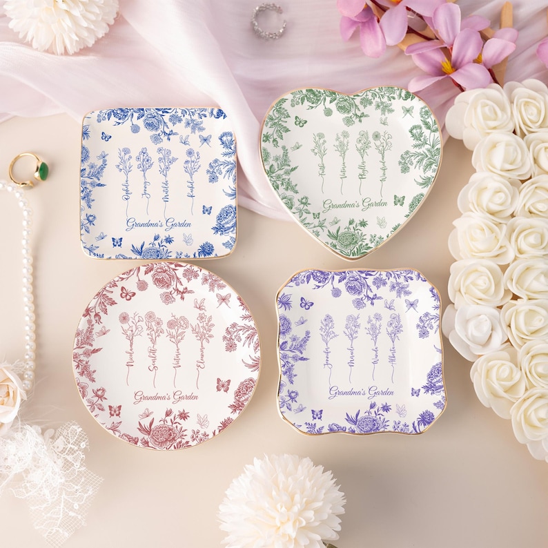 Pu&ograve; includere: Quattro piatti decorativi in ceramica di varie forme: quadrata, a cuore e rotonda. Ogni piatto presenta disegni floreali blu, verdi e rossi, con la scritta "Grandma's Garden". Farfalle e bordi dorati.