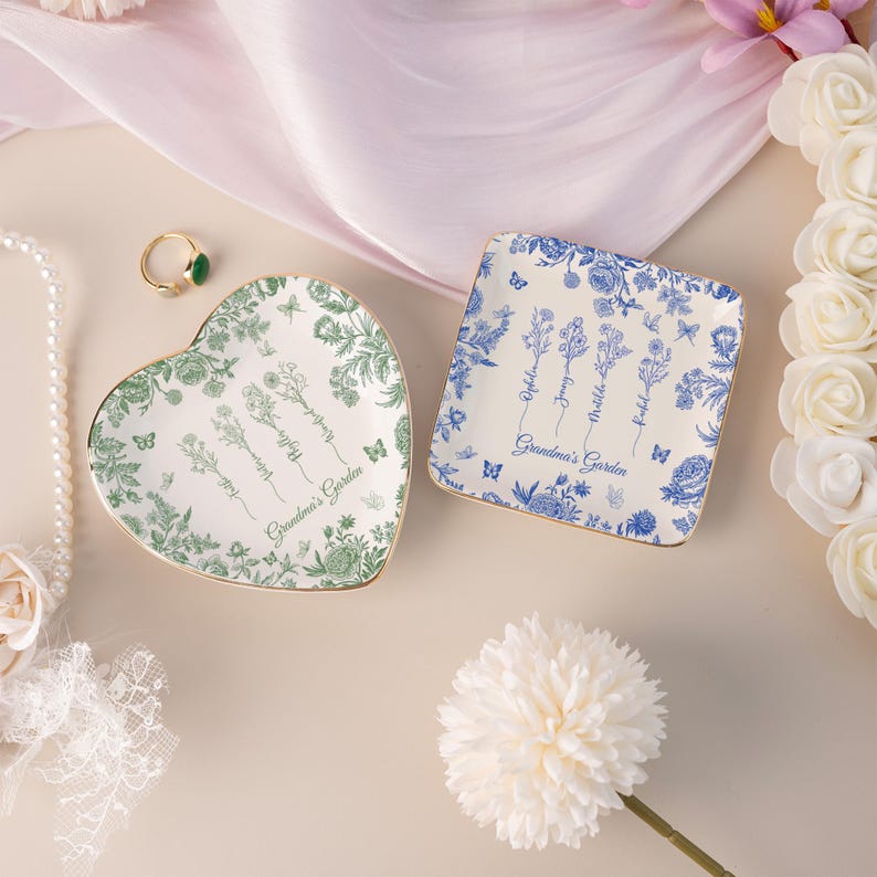 Pu&ograve; includere: Due piatti decorativi in ceramica. Uno a forma di cuore con un design floreale verde e bordi dorati, l'altro quadrato con un design floreale blu e bordi dorati. Entrambi i piatti hanno la scritta "Grandma's Garden".