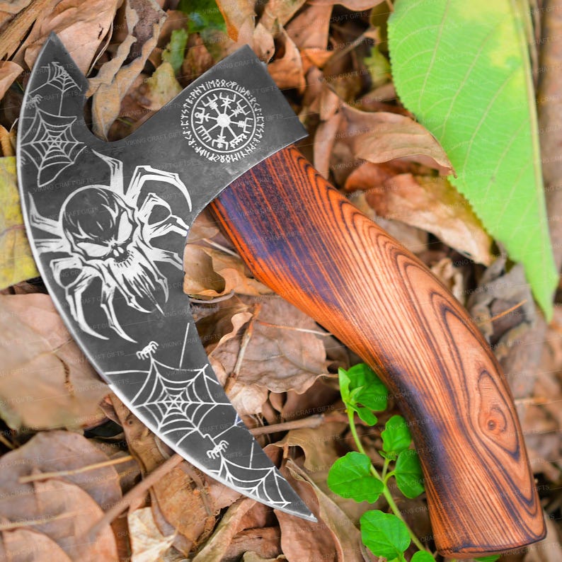 May include: A black and silver axe with a wooden handle. The axe head has a spider web design and a skull in the center. The handle is made of dark wood with a reddish brown stain. The axe head also has a circular design with runes and symbols.