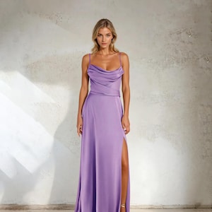 K&ouml;nnte beinhalten: Ein bodenlanges, lavendelfarbenes Kleid mit Wasserfallausschnitt und Spaghettitr&auml;gern. Das Kleid hat einen hohen Schlitz am linken Bein. Das Model tr&auml;gt goldene Sandalen.