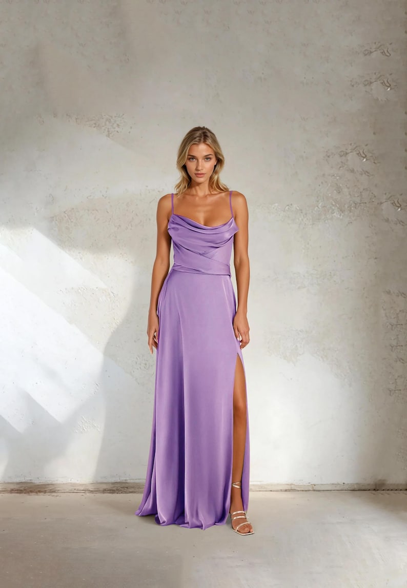 K&ouml;nnte beinhalten: Ein bodenlanges, lavendelfarbenes Kleid mit Wasserfallausschnitt und Spaghettitr&auml;gern. Das Kleid hat einen hohen Schlitz am linken Bein. Das Model tr&auml;gt goldene Sandalen.
