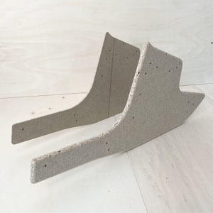 Puede incluir: Dos piezas de madera beige sin terminar para el respaldo de una silla.