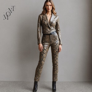 Pode incluir: Um conjunto de duas peças com padrão de pele de cobra. O conjunto inclui um blazer curto com lapela entalhada e calças justas a condizer. O conjunto é em tons de castanho e preto, combinado com botins pretos. A palavra "MONT" está no canto superior esquerdo.