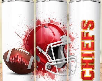 May include: White tumbler featuring a red football helmet, a brown football with a city skyline design, and the word "CHIEFS" in red and gold. The design includes red paint splatters. Includes a silver straw.