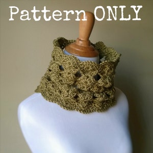 May include: A crocheted cowl in a green color with a textured pattern. The cowl is displayed on a white mannequin.