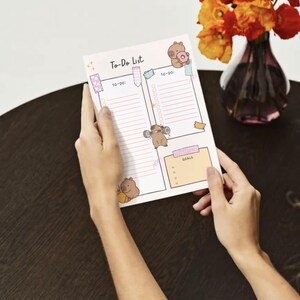 May include: A white to-do list with pink and blue accents. The list is divided into three sections: To-Do, To-Do, and Goals. Each section has a lined area for writing. The list is decorated with cartoon bears.