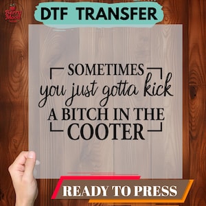 May include: A DTF (Direct to Film) transfer with the text "Sometimes you just gotta kick a bitch in the cooter." The transfer is ready to press and features a bold, black font. The background is a light wood grain.