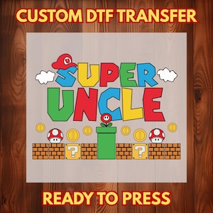 May include: A DTF transfer design featuring the words "SUPER UNCLE" in colorful, block letters, with a red hat and cloud accents. The design includes coins, mushrooms, and a green pipe, with the text "CUSTOM DTF TRANSFER" and "READY TO PRESS".