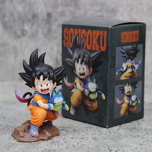 Figura infantil de Son Goku sosteniendo una pluma en sus manos.
