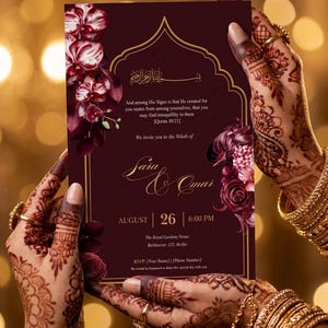 May include: Burgundy wedding invitation with floral accents, held by hands adorned with henna and gold jewelry. The invitation includes the names "Sara & Omar", date, time, and venue details.
