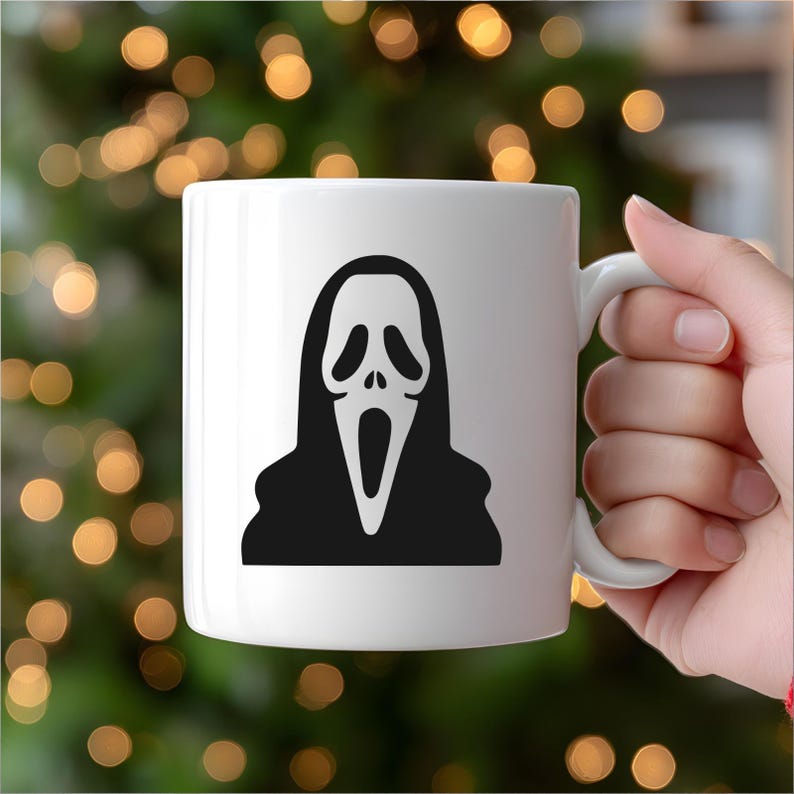 May include: White ceramic mug featuring a black and white graphic of the Ghostface mask from the Scream horror film series. The mug has a curved handle and a glossy finish, perfect for coffee or tea. A spooky addition to any Halloween or horror fan's collection.