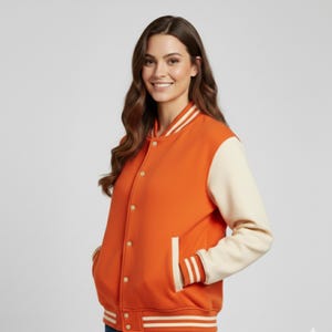 May include: Orange and cream varsity jacket with white striped detailing on the collar, cuffs, and hem. The jacket has a button-up front and side pockets. A classic, sporty outerwear item.
