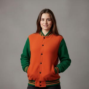 May include: Orange and green varsity jacket with black buttons. The jacket has green sleeves and a green and orange striped collar, cuffs, and waistband. The jacket is made of a soft, textured material.