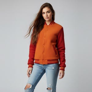 May include: Orange and red varsity jacket with button closure, ribbed cuffs, and a striped waistband. The jacket has a textured fabric and a classic athletic style. The sleeves are a solid red, and the body is orange.