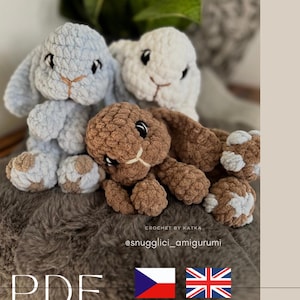 Puede incluir: Tres conejos de crochet hechos a mano en azul claro, blanco y marrón. Los conejos tienen ojos negros y narices y bocas cosidas de color beige. La imagen incluye el texto "CROCHET BY KATKA", "@snugglici_amigurumi" y "PDF".