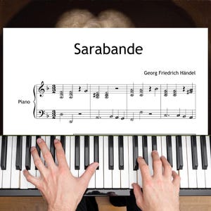 Może przedstawiać: Nuty do "Sarabande" Georga Friedricha Händla, ze słowem "Piano" po lewej stronie. Ręce osoby grają na pianinie, z czarno-białymi klawiszami. Tytuł "Sarabande" jest napisany pogrubioną, czarną czcionką.