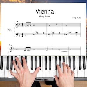 Może przedstawiać: Nuty do utworu "Vienna" (Easy Piano) Billy'ego Joela. Na pierwszym planie klawiatura fortepianu z rękami pianisty. Nuty są na białym tle.