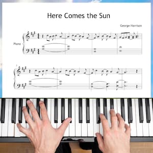 May include: A piano keyboard with black and white keys. The sheet music for "Here Comes the Sun" by George Harrison is visible above the keyboard. The hands of a person are playing the piano.