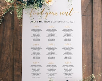 May include: A white wedding seating chart with gold calligraphy that reads "Find your seat". The chart lists the names of guests assigned to each table number. The chart is displayed on a wooden easel with flowers in front of it.