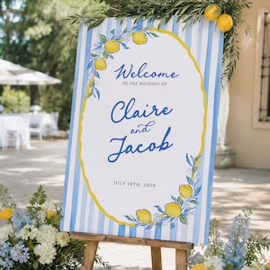 May include: A rectangular wedding welcome sign featuring blue and white vertical stripes, a central white oval with a yellow border, and lemon illustrations. The text reads: Welcome TO THE WEDDING OF Claire and Jacob JULY 16TH, 2029.