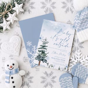 Op de afbeelding: Een rechthoekige uitnodigingskaart voor een babyshower met een aquarel dennenboom, blauwe sneeuwvlokken en de tekst Baby it's cold outside, Join us for a baby shower in honor of the mom to be, Ethan Miles, Saturday, 09.12.2023, Miles Family House.