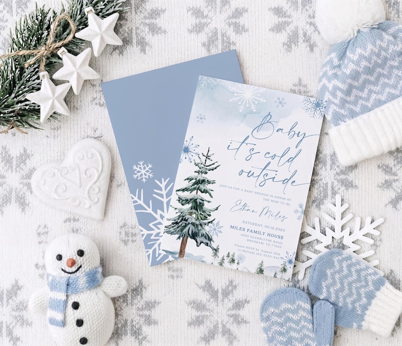 Op de afbeelding: Een rechthoekige uitnodigingskaart voor een babyshower met een aquarel dennenboom, blauwe sneeuwvlokken en de tekst Baby it's cold outside, Join us for a baby shower in honor of the mom to be, Ethan Miles, Saturday, 09.12.2023, Miles Family House.