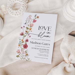 Editable bridal shower invitation template with romantic wildflower watercolor design, featuring soft pink, yellow, blue, and burgundy florals on a white background, paired with elegant serif and modern script fonts