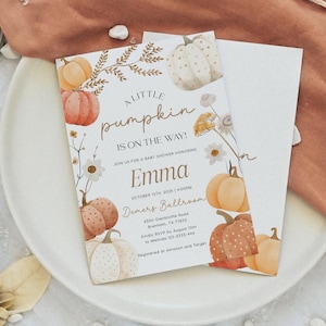 May include: Baby shower invitation with a pumpkin theme. The invitation features watercolor pumpkins in shades of orange, peach, and white, along with floral accents. The text reads "A Little Pumpkin is on the Way!" and includes the name "Emma" and event details.