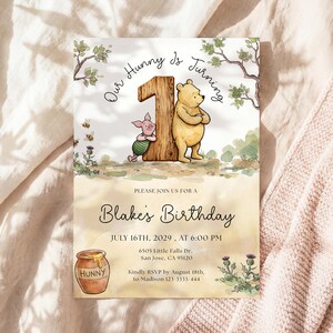 Watercolor illustration of a classic Winnie the Pooh and Piglet standing by a large wooden number one, featuring a honey pot, bees, and thistles on a soft yellow wash background.