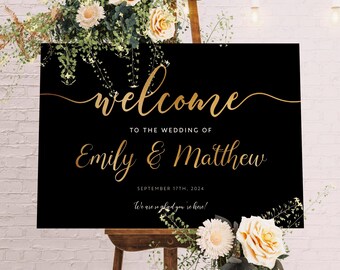 Puede incluir: Un letrero de bienvenida de boda negro con letras doradas que dice "welcome" y los nombres "Emily & Matthew". El letrero está sobre un caballete de madera y decorado con flores y vegetación. La fecha es el 17 de septiembre de 2024.