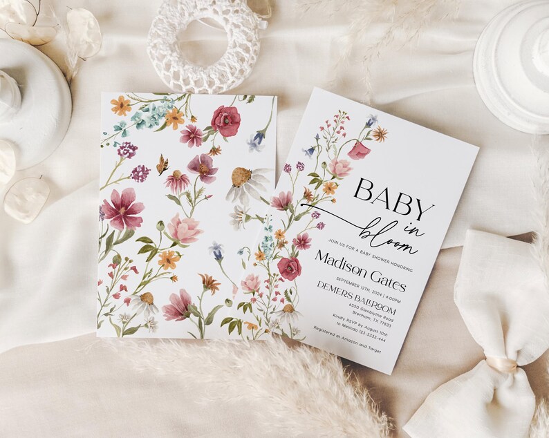 Editable “Baby in Bloom” baby shower invitation template featuring a soft watercolor wildflower border in blush, burgundy, yellow, and lavender, with elegant serif and script fonts on a white background, customizable via Templett