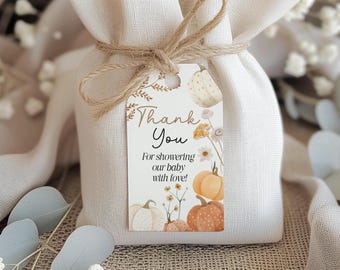 May include: A small, beige fabric gift bag tied with twine, featuring a tag with the words "Thank You" and a watercolor design of pumpkins and flowers. The tag reads "For showering our baby with love!"