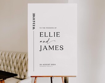 May include: A white wedding welcome sign on a wooden easel. The sign features black text: "WELCOME", "TO THE WEDDING OF ELLIE and JAMES", and the date "26 AUGUST 2024". The sign is displayed in a well-lit room, with a neutral background.