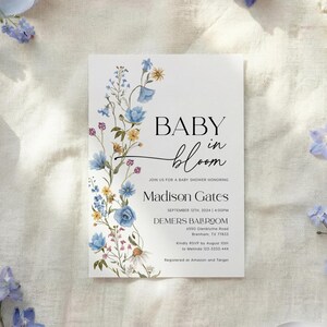 Watercolor blue delphinium and yellow wildflower border framing modern sans-serif typography on a white background.