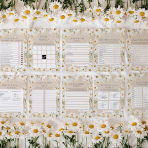 May include: A collection of ten baby shower game cards with daisy floral borders. The cards feature various game titles such as "Baby Bingo", "Wishes for Baby", and "Guess Baby Food". White daisies are arranged around the cards.