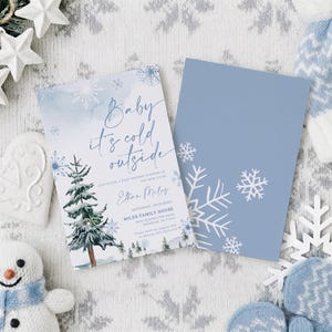 Op de afbeelding: Een rechthoekige uitnodigingskaart voor een babyshower met een aquarel dennenboom, blauwe sneeuwvlokken en de tekst Baby it's cold outside, Ethan Miles, Saturday, 09.12.2023, Miles Family House, 4500 Glenblythe Road, Denham, TX 77500, en een bijpassende blauwe kaart.
