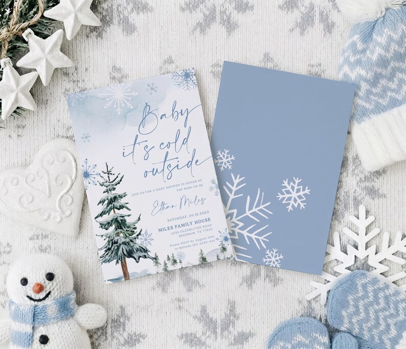 Op de afbeelding: Een rechthoekige uitnodigingskaart voor een babyshower met een aquarel dennenboom, blauwe sneeuwvlokken en de tekst Baby it's cold outside, Ethan Miles, Saturday, 09.12.2023, Miles Family House, 4500 Glenblythe Road, Denham, TX 77500, en een bijpassende blauwe kaart.