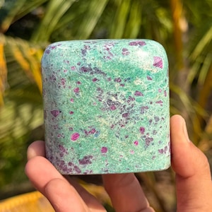 May include: A polished, rectangular-shaped stone specimen featuring a vibrant mint green base color with scattered, irregular deep magenta and dark purple inclusions throughout the surface, displaying a smooth texture and rounded top edges.