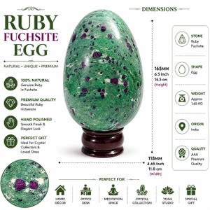Puede incluir: Un huevo de rubí en fuchsite pulido con inclusiones verdes y rojo oscuro, sobre una base de madera oscura. El huevo mide 16,5 cm de alto y 11,8 cm de ancho. El texto en la imagen incluye Ruby Fuchsite Egg, 100% Natural y 1,65 kg.