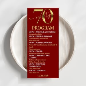 May include: A red and gold 70th birthday program card with a detailed schedule of events. The card is set on a white plate. The program includes welcome, toasts, dinner, dessert, and dancing. The date is March 22, 2026.